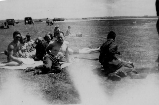 Kenneth Figg with company. Figg is wearing sunglasses and smoking  on the extreme left of the shot. 